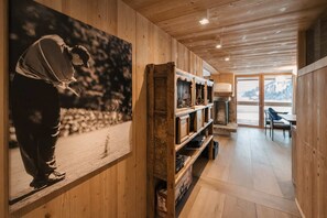 Een houten interieur met een grote zwart-wit foto, houten planken en uitzicht door een raam.
