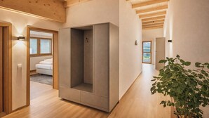 Interior moderno com vigas de madeira, um guarda-roupa espaçoso, uma planta e vista pela janela.
