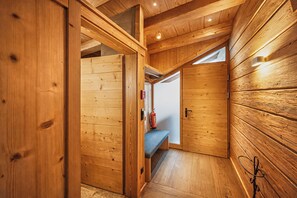 A wooden interior with a bench, a fire extinguisher, and a door leading to another room. - GOLF Suite – Penthouse & Sauna Access (Kleinboden)