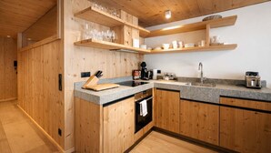Eine moderne Küche mit Holdekor-Schränken, Granit-Arbeitsplatten und integrierten Regalen für Gläser.