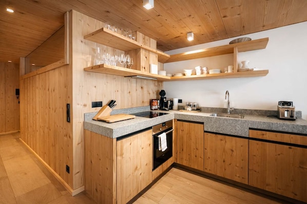 Eine moderne Küche mit Holdekor-Schränken, Granit-Arbeitsplatten und integrierten Regalen für Gläser.