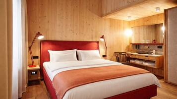 Una stanza con rivestimenti in legno, un letto, comodini, una scrivania e uno specchio.