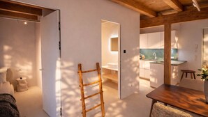 Um interior moderno com escada de madeira, área de refeições e cozinha.