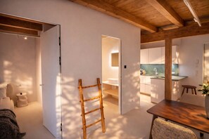 A modern interior with a wooden ladder, a dining area, and a kitchen. - PENTHOUSE N'3 – Sauna & Whirlpool Access (Kramsach)