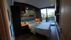 A hotel room with a bed, a nightstand, a lamp, a wall-mounted shelf with a paddleboard, and a large window with a view. - Merepe Suites 103 by La Playa (Ipojuca)