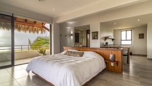 Une chambre moderne avec un grand lit, un bureau en bois et un balcon avec vue.