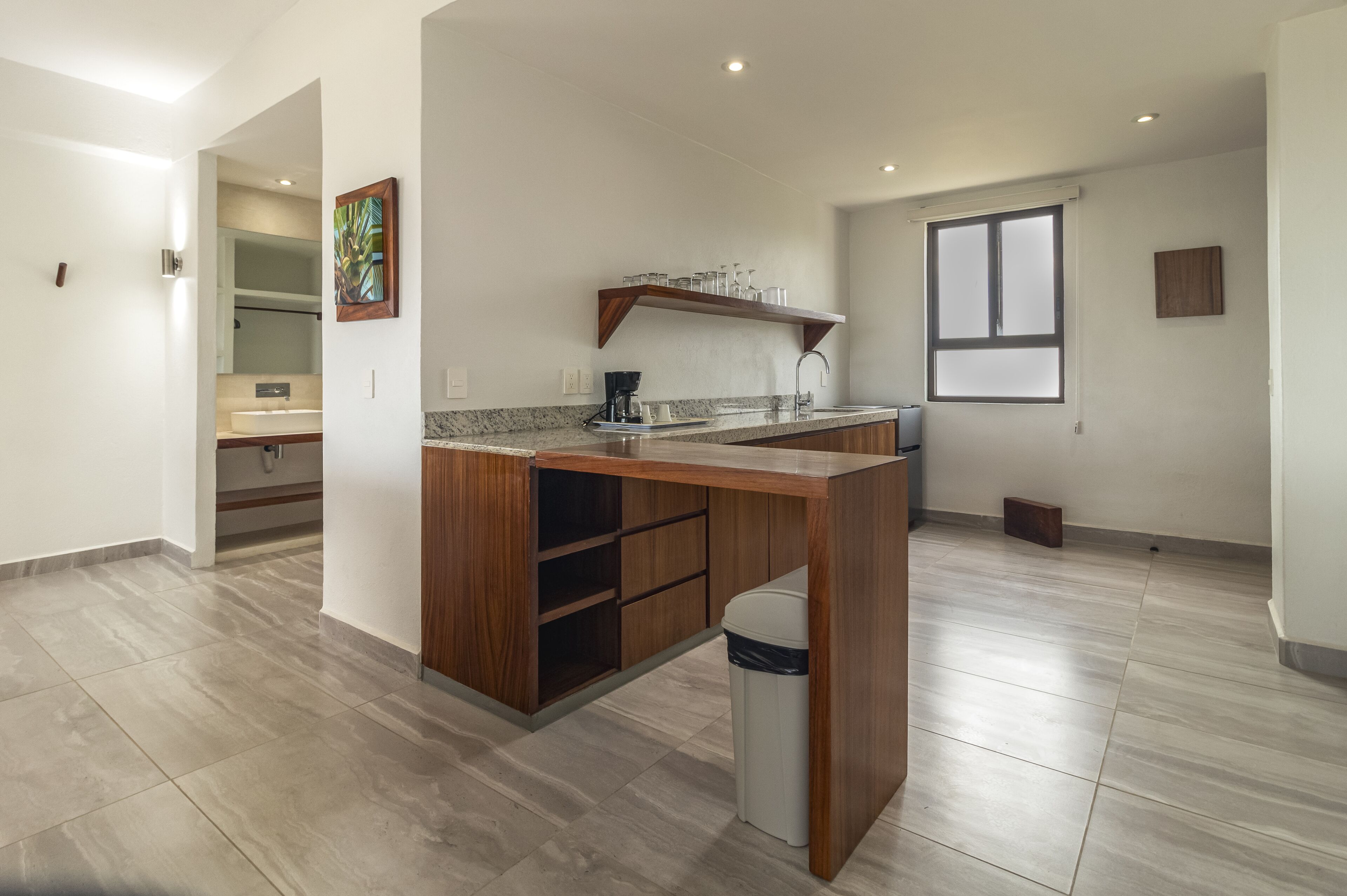 Una cocina moderna con una isla de madera, armarios empotrados y un ventanal grande.