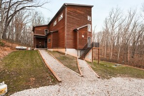 A modern two-story wooden house with a gravel driveway and a staircase leading to the entrance. - Starr & Sky Lodge | Hocking Hills, Hot Tub, Sauna (Logan)