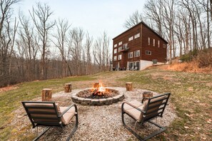 A building with a fire pit and two chairs in the foreground. - Starr & Sky Lodge | Hocking Hills, Hot Tub, Sauna (Logan)