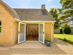 A house with a patio, a dining area, and a garden. - Spacious Cotswolds Home-Large Garden-Games Room (Finstock)