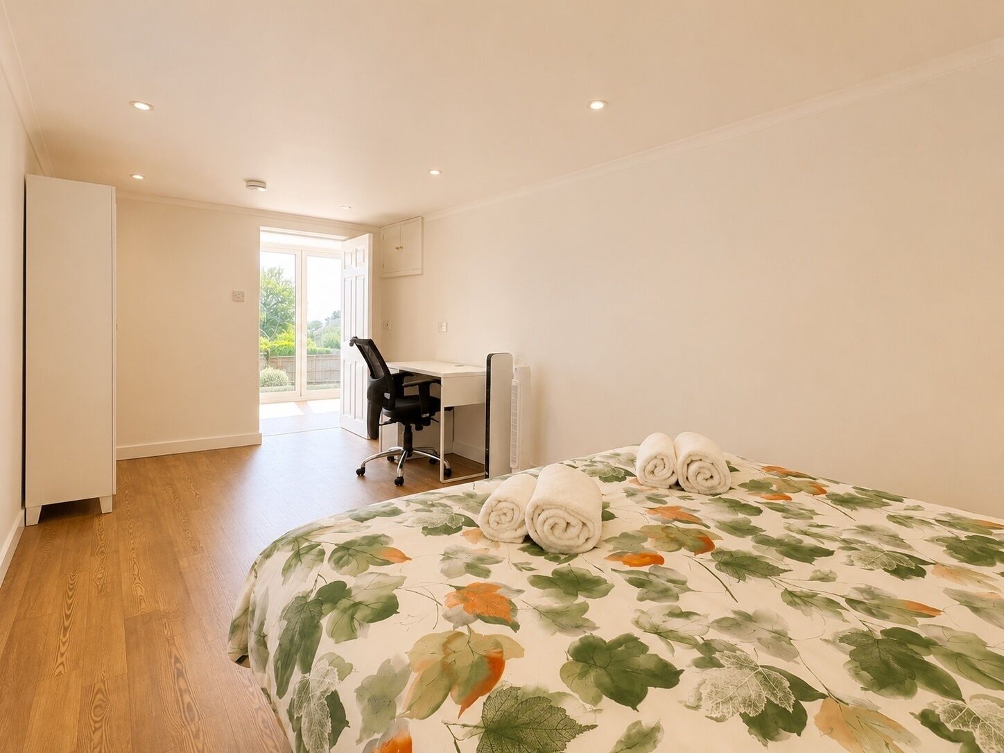 Une chambre d’hôtel avec un lit, un bureau et une chaise.