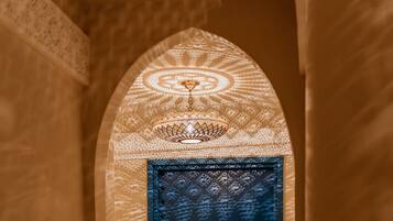 A blue door with a patterned wall and a textured floor.