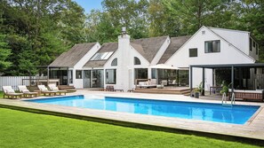 A modern house with a swimming pool, outdoor seating, and a covered patio. - Modern East Hampton Retreat, Exquisitely Appointed with a Private Pool,... (East Hampton)