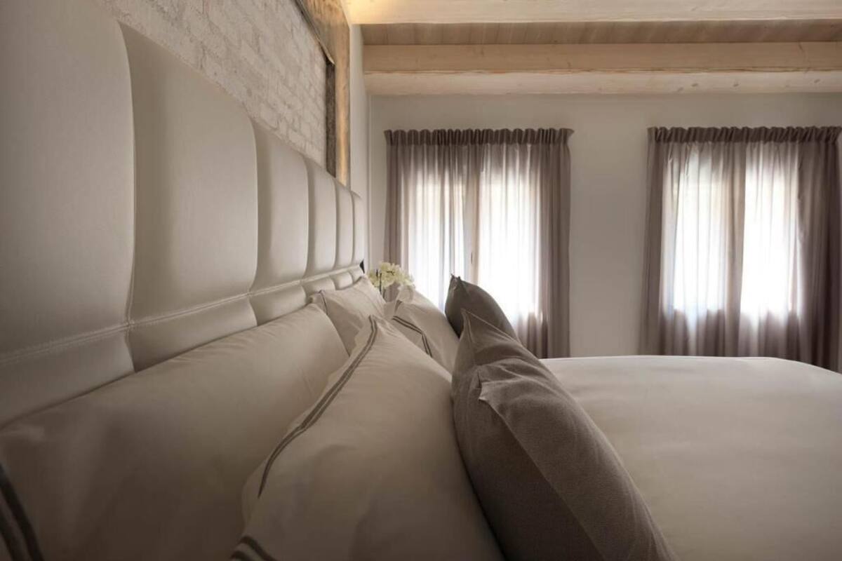 Ein Schlafzimmer mit einem großen Bett, einem Kopfteil und Vorhängen.