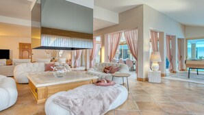 Un salon spacieux avec un grand canapé, une table basse et une cheminée.
