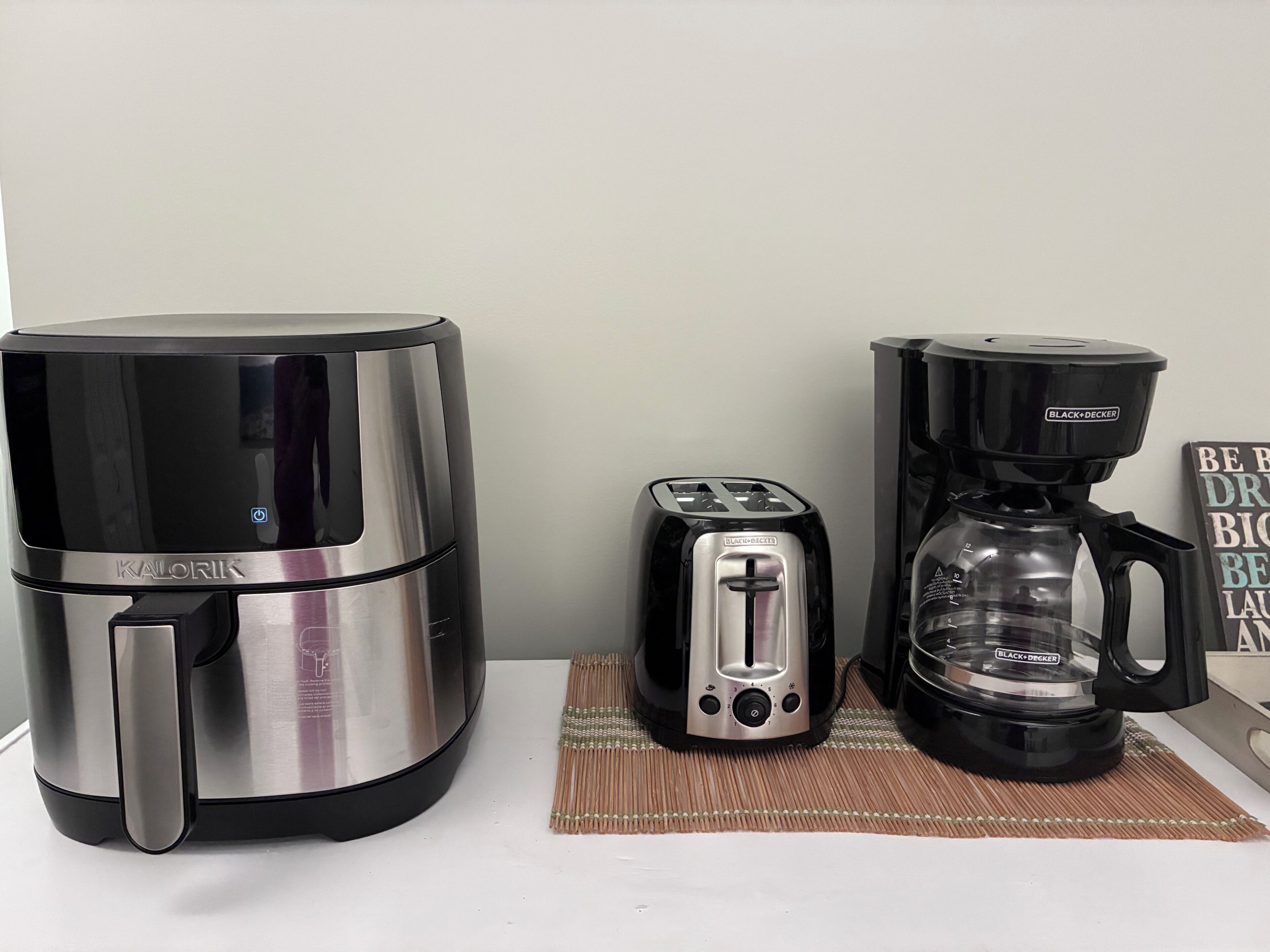 A kitchen with a coffee maker, toaster, and kettle.