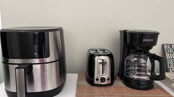 Een keuken met een koffiezetapparaat, broodrooster en waterkoker.