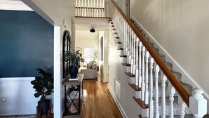 A hallway with wooden flooring, a staircase with white balusters, and a chandelier. - 11 miles to the Augusta National Golf Club! Your home for the Masters Tournament (Grovetown)