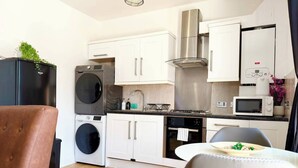 Eine kompakte Küche mit Waschmaschine, Mikrowelle, Herd und Backofen.