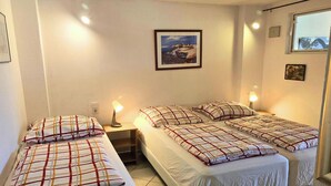 A room with two beds, a nightstand, a lamp, and a framed picture on the wall. - Mobile Home im Ferienpark mit Seezugang (Dabel)