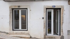 En bygning med to nummererede vinduer, hvor det ene har en lukket dør og det andet en åben dør.
