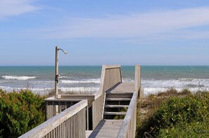 A wooden boardwalk leading to the ocean with a metal lamp post. - Southern Aire - a spacious 5-bedroom oceanfront in Surf City, NC (Surf City)