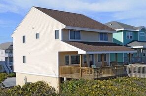A two-story residential building with a balcony, a covered porch, and a view of neighboring houses. - Southern Aire - a spacious 5-bedroom oceanfront in Surf City, NC (Surf City)