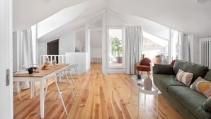 A spacious loft with a dining area, a sofa, and a view of the outdoors. - Spacious 6-Bedroom Apt w/ Sunny Terrace in Lisbon (Lisbon)