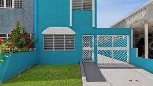 Ein Gebäude mit blauer Fassade, einem verschlossenen Eingang und einem kleinen Rasen.