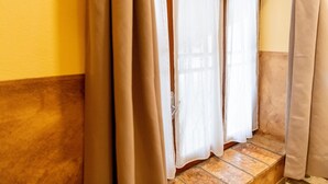 Un racó d'una habitació amb una finestra, una porta i un sòl de rajola.