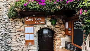 A stone building with a wooden sign reading 'Cave Bar La Cueva' and a blackboard with event information. - Holiday Home 'Los Naranjos' with Shared Pool, Wi-Fi and Air Conditioning (Nerja)