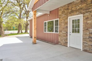 A building with a stone facade, a wooden post, and a white door. - Newly Built 3BD 2BTH| Kid+Pet Friendly|Sleeps 7 (Spirit Lake)