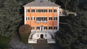 Un immeuble à plusieurs étages, doté d’une façade symétrique, d’une entrée centrale et entouré d’un espace paysager.