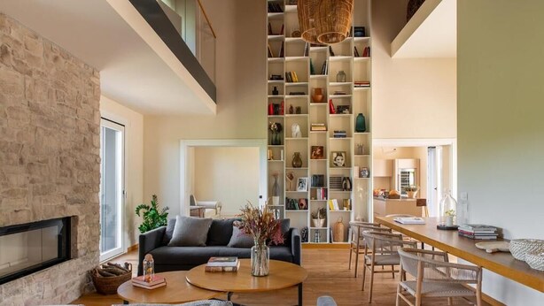 Un salon moderne avec une cheminée, un canapé, une table basse et une bibliothèque.