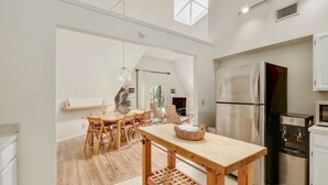 Eine moderne Küche mit Kühlschrank, Wasserspender und Essbereich mit Tisch und Stühlen.