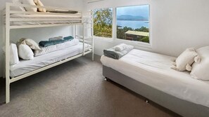 Ein Mehrbettzimmer mit Blick auf einen See und Berge.