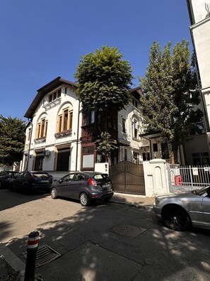 Ein Gebäude im klassischen Baustil, mit Rundbogenfenstern und einem Balkon.