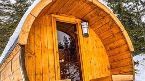 Una cabaña de madera con una entrada arqueada, una ventana y una lámpara.