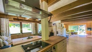 Una cocina moderna con estufa integrada, armarios de madera y un amplio ventanal.