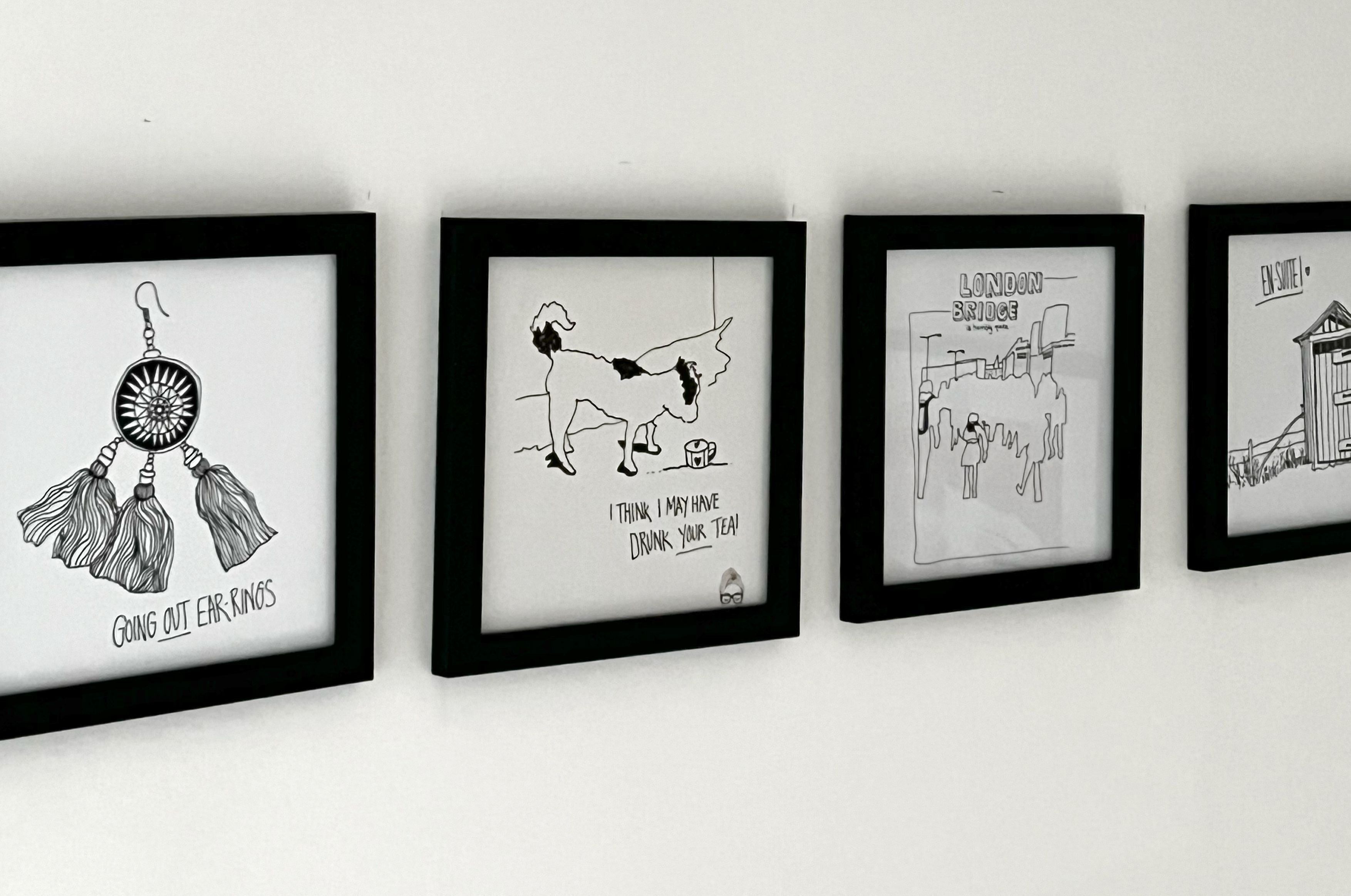 Quatre dessins en noir et blanc, encadrés, sont accrochés au mur.