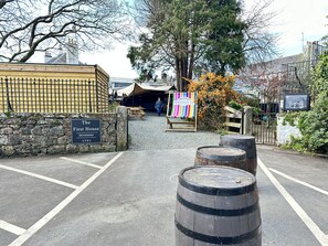A parking area with a stone wall, a wooden fence, and a sign for 'The First House Inveraray 1751'. - Quay Cottage Luxury 2 Bedroom Cottage in Quiet Spot in Heart of Inveraray - Super Kingsize Bed (Inveraray)