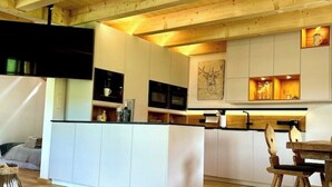 A modern kitchen with white cabinetry, a central island, and wooden accents.