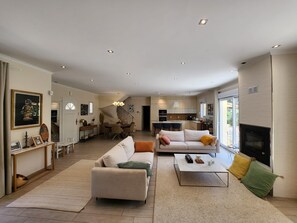 A spacious living area with a sofa, coffee table, and a fireplace. - HAPPYFEW VILLA LAGHET (La Trinité)