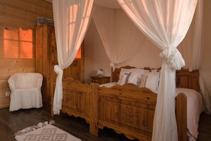 A wooden four-poster bed with a canopy, a bedside table, and a chair in a room with wooden walls. - Comfortable Apartment With Terrace, Close to Beach (gmina Będzino)