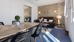 Una sala de estar moderna con comedor, un sofá, una mesa de centro y una lámpara.