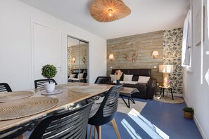 Un salon moderne comprenant un coin repas, un canapé, une table basse et une lampe.