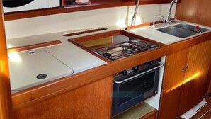 Una cuina petita i funcional amb microones, rentamicrodats, fogó i forn.