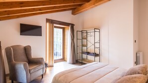 A bedroom with a bed, a chair, a wardrobe, and a window.