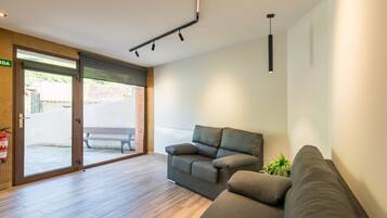Un salon moderne avec un canapé, un banc et une porte donnant sur un espace extérieur.