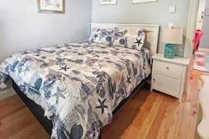 A bedroom with a bed, nightstand, and a mirror.